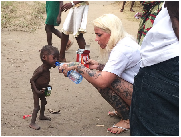 Аня Ловен кормит и поит двухлетнего нигерийского малыша, найденного на улице.