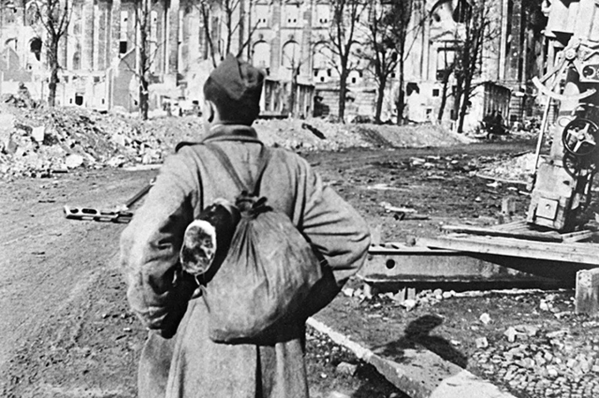    Боец-пехотинец Михаил Макаров перед поверженным Рейхстагом. 21 мая 1945 года.