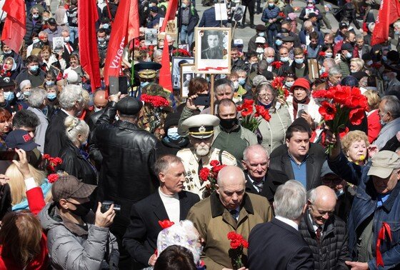    9 мая 2021 года, Киев, Украина: люди несут портреты Второй мировой войны и цветы к памятнику Неизвестному Солдату в честь Дня Победы