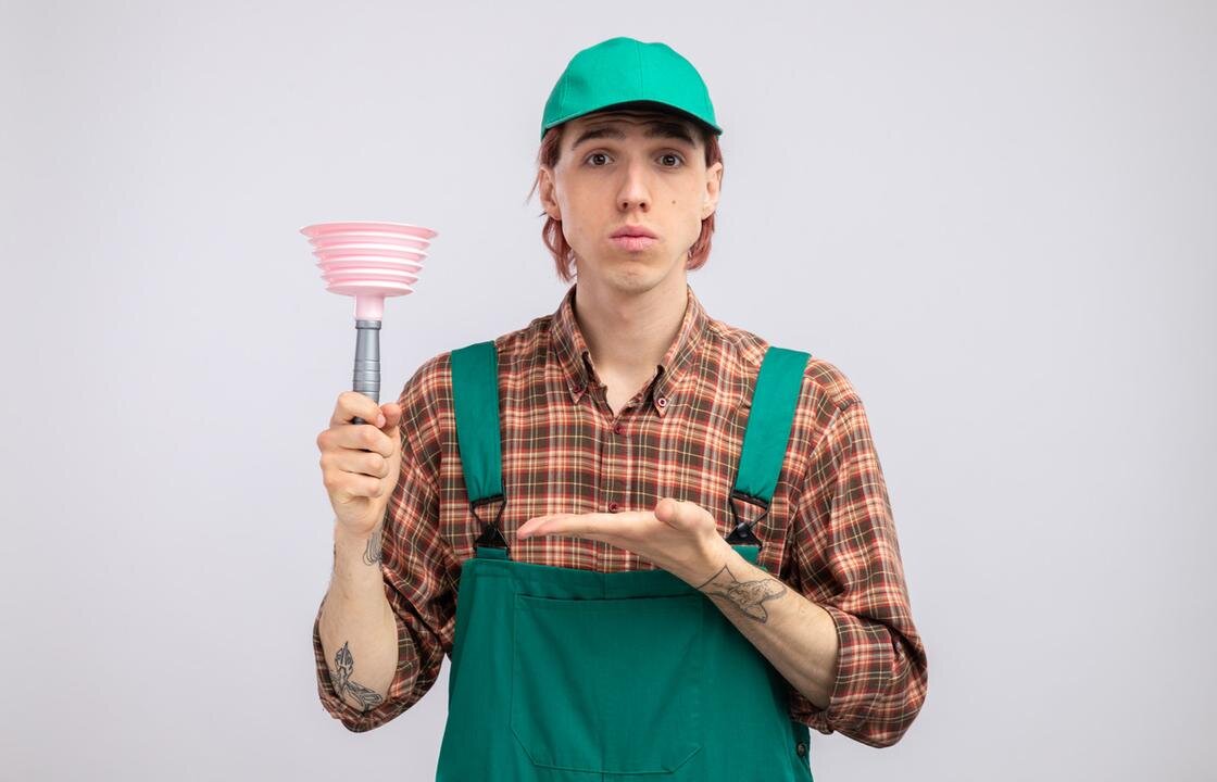    Сантехник в зеленом костюме с вантузом в руке:Freepik