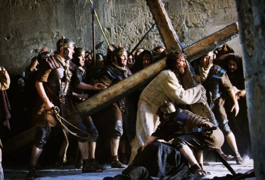 Иисус несёт крест на Голгофу. Кадр из фильма «Страсти Христовы» (2004 г., режиссёр Мел Гибсон).
