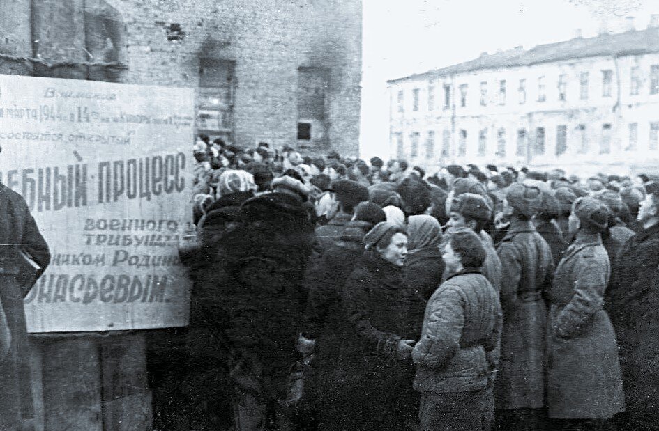 Объявление на городской площади, информирующее граждан о судебном процессе над изменником Родины.