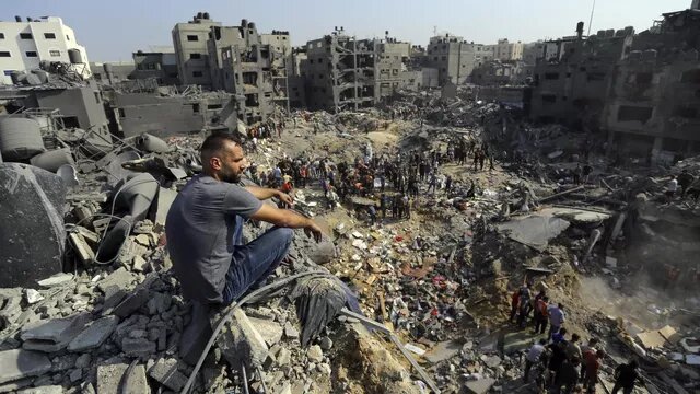 © AP Photo / Abed Khaled Мужчина на обломках разрушенных после израильского авиаудара зданий в лагере беженцев Джабалия на севере сектора Газа. Архивное фото