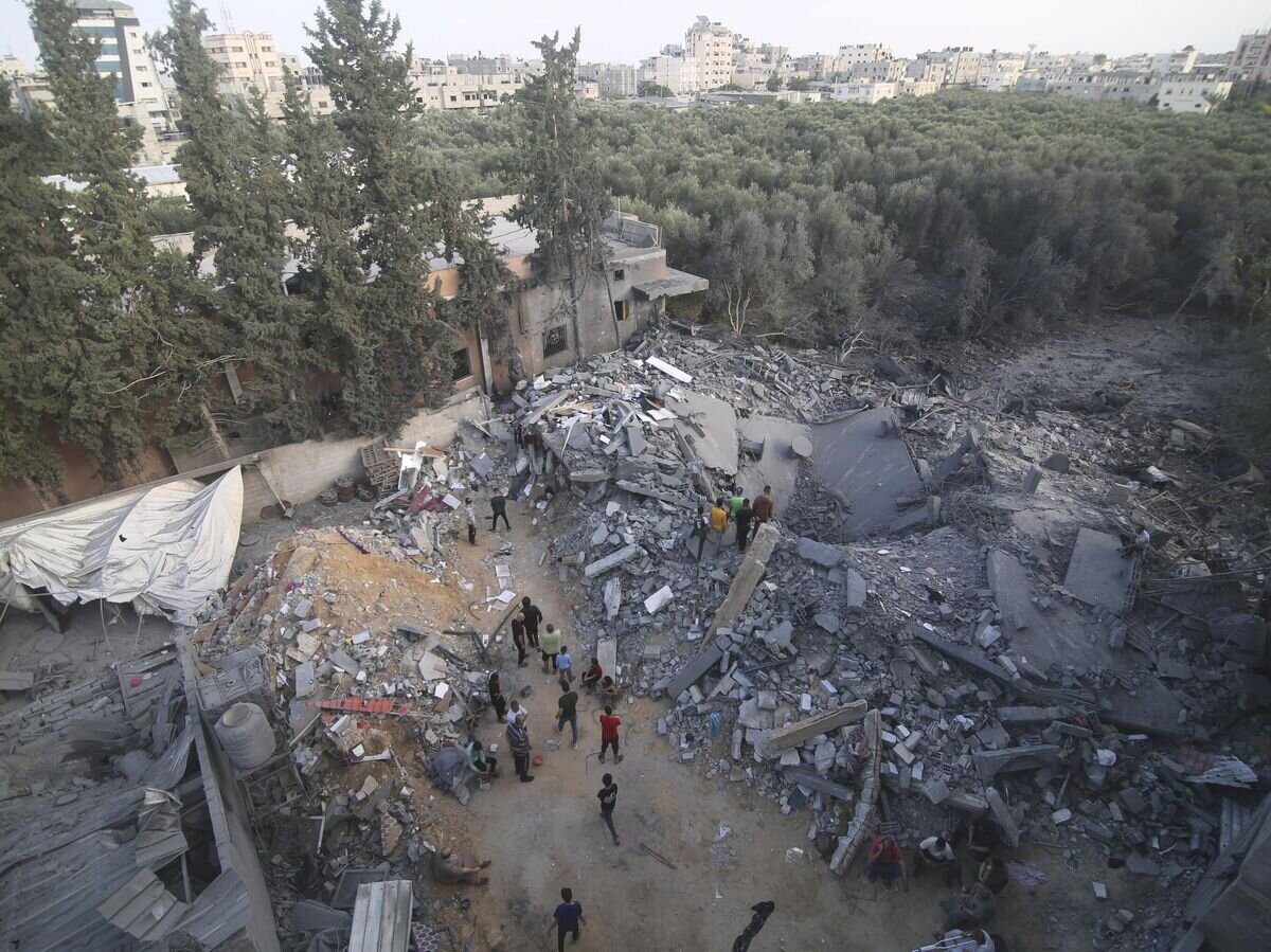    Палестинцы стоят у здания, разрушенного в результате израильского авиаудара, в Рафахе, сектор Газа© AP Photo / Hatem Ali