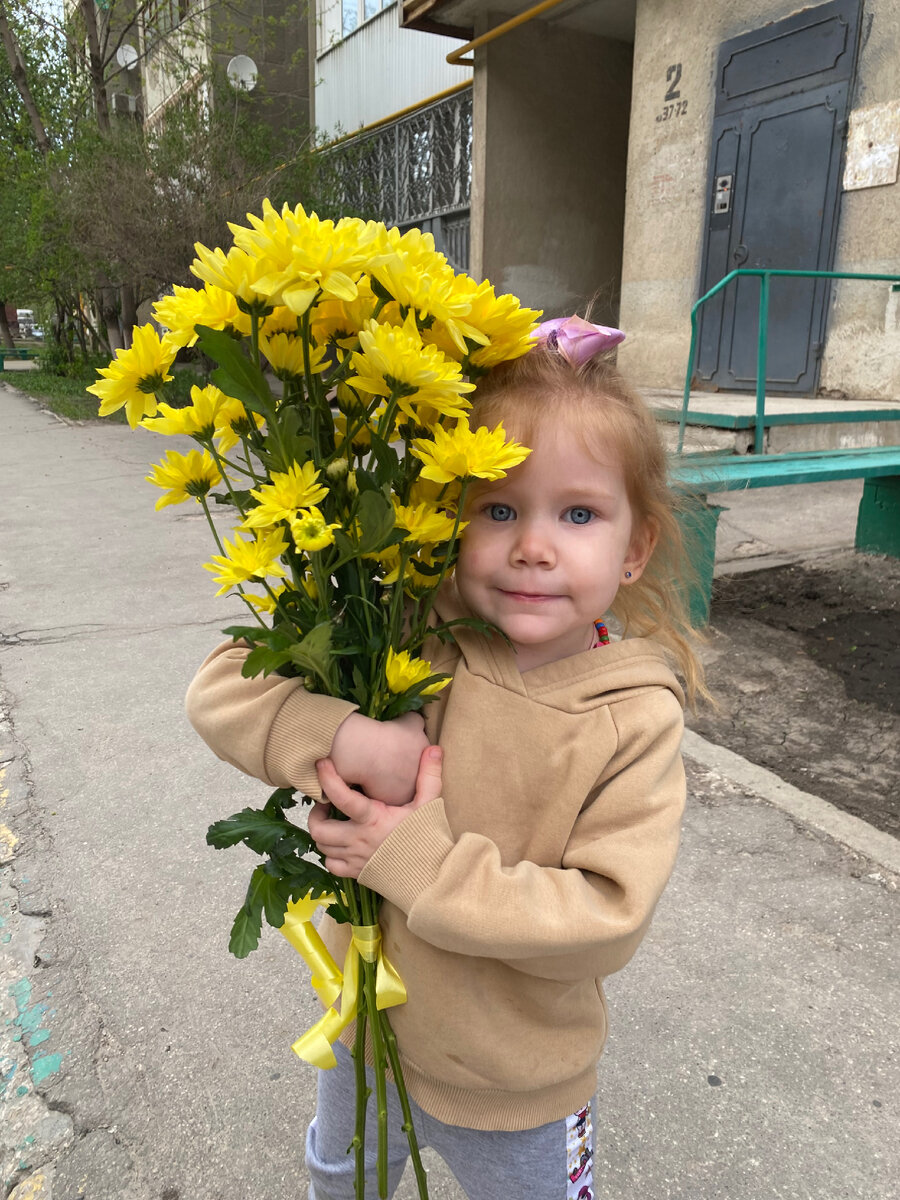 Несёт бабушке её любимые цветы 