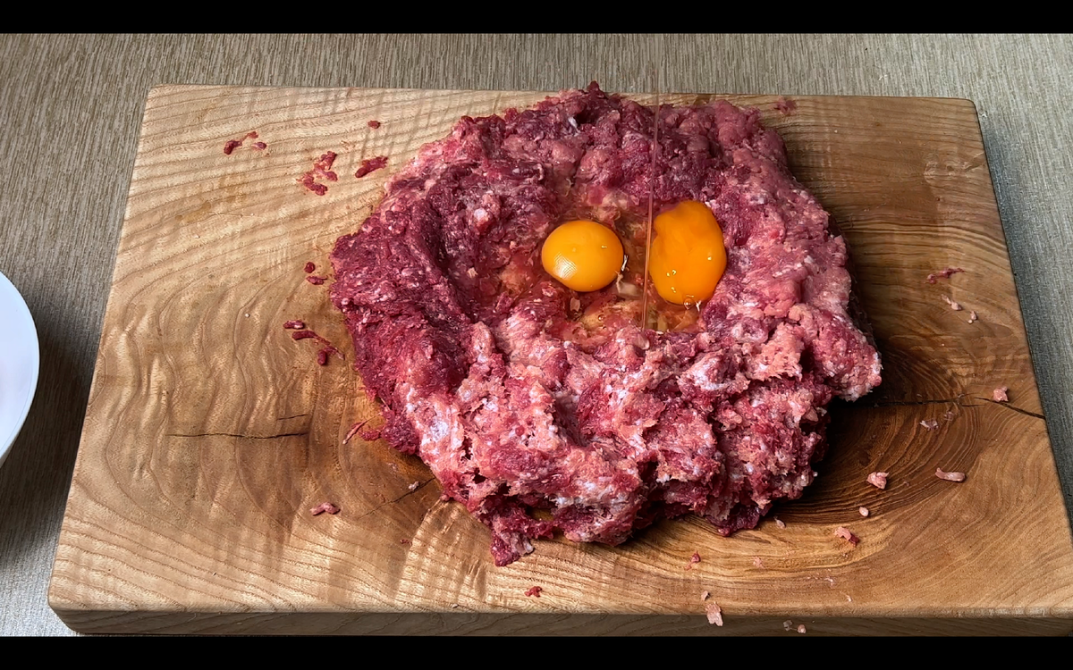 Для приготовления котлеты для сендвича нам нужно смешать 500г говяжего и 500г свиного фарша, вбить два куриных яйца, добавить соль перец по вкусу, 50 мл воды и все тщательно перемешать.