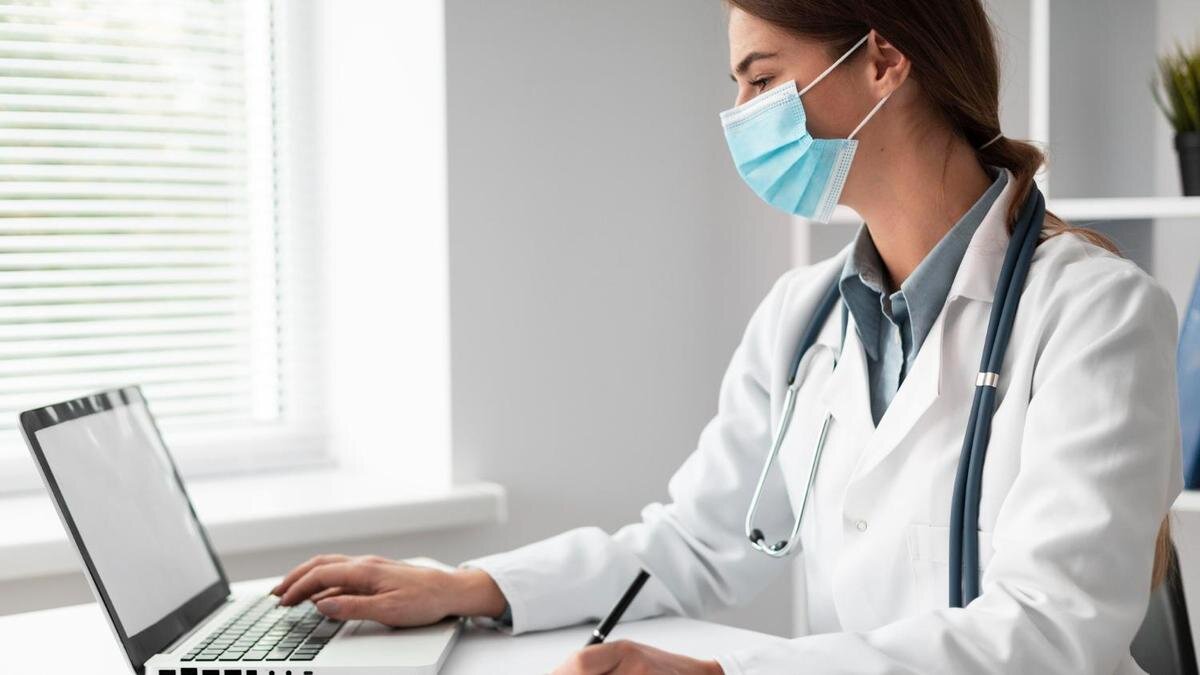    Девушка-доктор работает за компьютером:Freepik