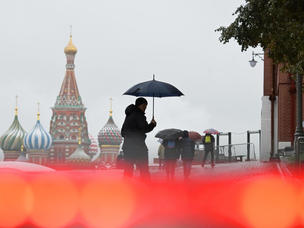    Мужчина во время дождя на Красной площади в Москве© РИА Новости / Евгений Биятов