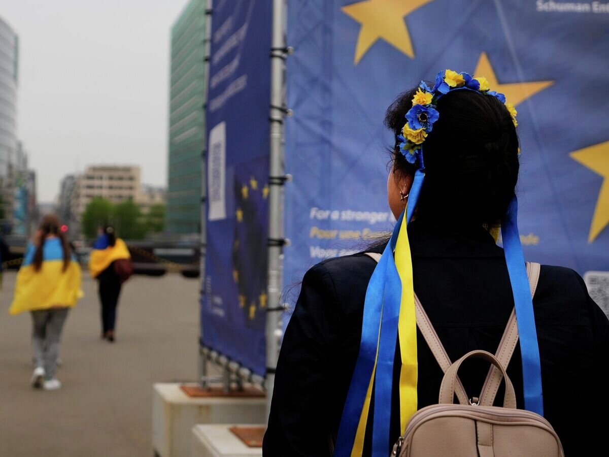    Протестующие несут украинские флаги, принимая участие в демонстрации возле штаб-квартиры ЕС в Брюсселе© AP Photo / Virginia Mayo