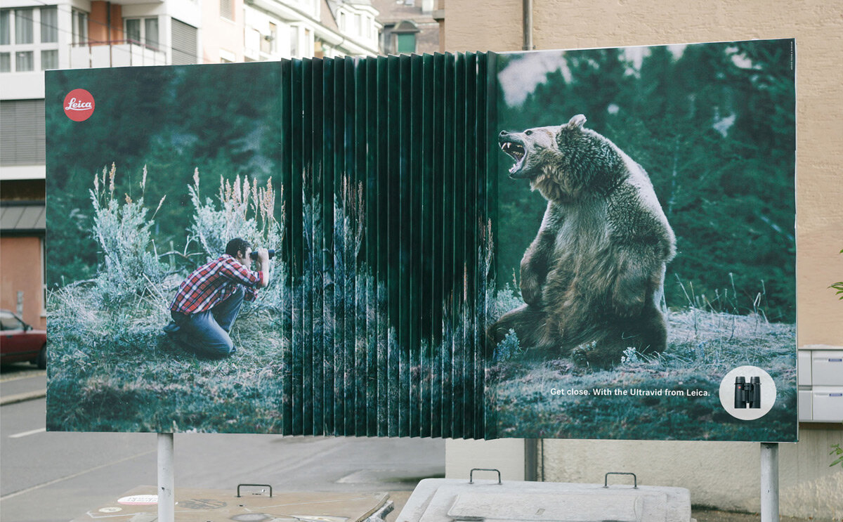 Креатив этой наружной рекламы зоопарка заключается в использовании двухмерного изображения, создающего иллюзию близости между фотографом и медведем, чтобы подчеркнуть, насколько близко можно наблюдать животных в зоопарке. 