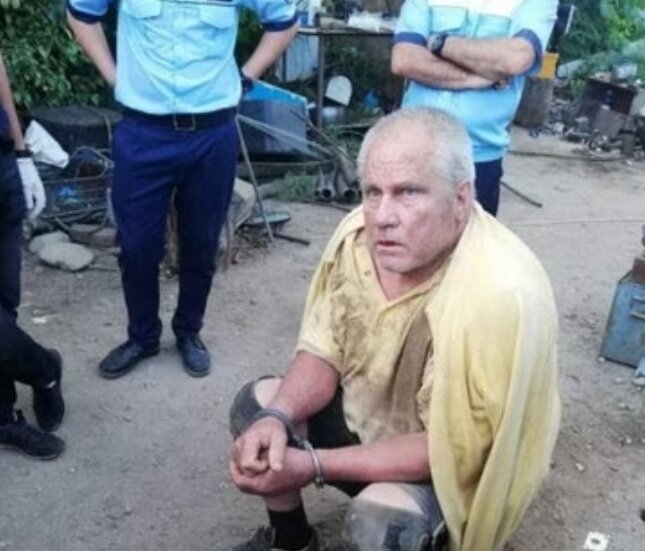 На фото 66-летний Георге Динке сразу после ареста на заднем дворе его дома. 