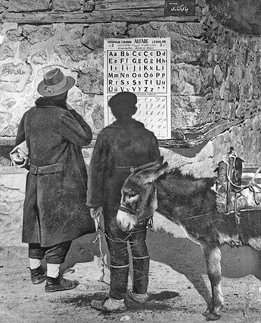 Двое турок изучают новые буквы на плакате, висящем перед ратушей, 1928 г. 