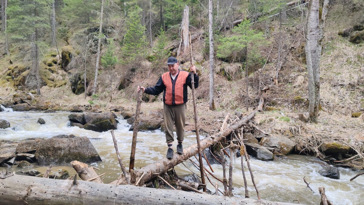 Андрей показывает мастер класс перехода по лесине через реку