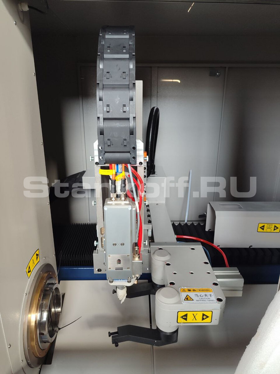 Лазерная режущая голова c автофокусом Ospri LC40. Под лазерной головой расположен пневмозахват для вытягивания трубы из зоны погрузки и её удержания в момент раскроя.

