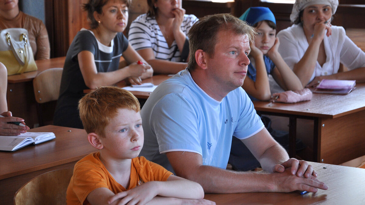 Родители и дети в школе на собрании