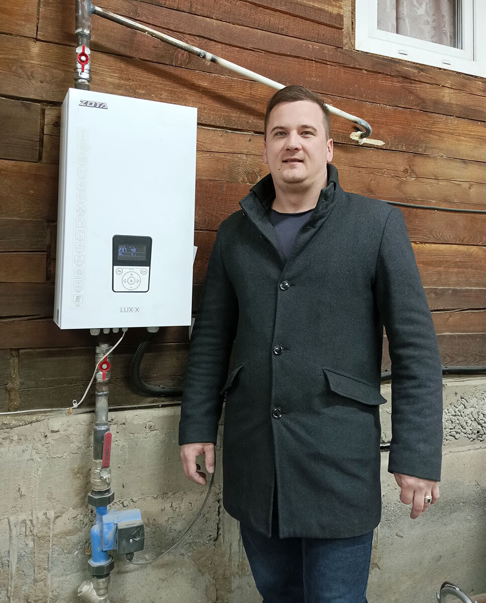 Глава семьи Алексей Никулин показывает, как выглядит электрокотёл. Такая техника занимает минимум места