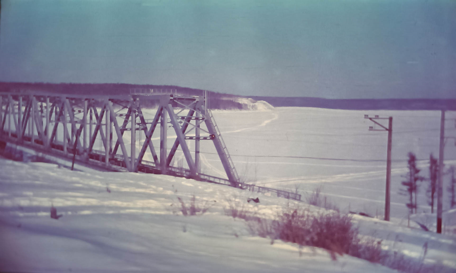 Рис. 2. Зимний вид с западного берега на просторы Зейского водохранилища. На переднем плане – красавец-мост, по которому проходит путь БАМа. Станция Верхнезейск – на противоположном берегу, туда ведёт ледовая дорога. Вправо уходит другая ледовая дорога, которая ведёт в посёлок Хвойный.
