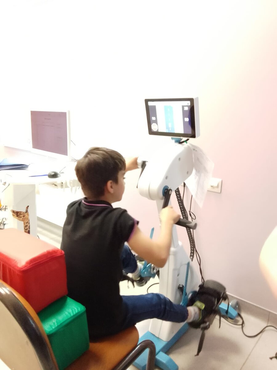 Неврологический тренаж: надо скоординировать движения рук и ног так, чтобы машинка на экране ехала по своей полосе и не попала в аварию. Сеня справился.