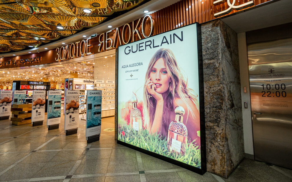Эта наружная реклама в торговом центре Золотое Яблоко представляет новый аромат Aqua Allegoria от Guerlain, выделяясь ярким изображением модели и информации о продукте. 