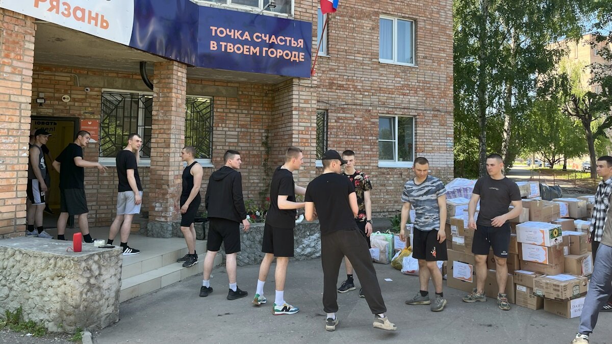 Волонтёры по цепочке передают товары и грузят в машину. Фото: Добро.Центр города Рязани