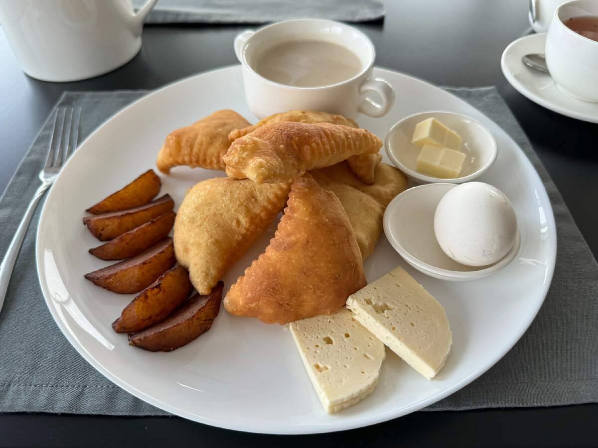 Завтрак в ресторане отеля "ШАТО", Махачкала, Дагестан. Завтрак горца: треугольные пышки, отварное яйцо, запеченный в печи картофель, масло, брынзу, калмыцкий чай