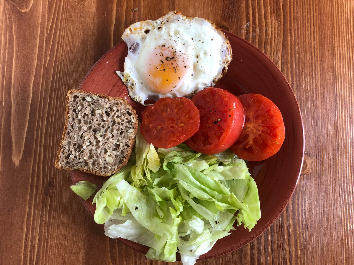 Мой завтрак для радости, здоровья и похудения: 1 поджаренное яйцо, 1 поджаренный помидор , кусочек ржаного цельнозернового хлеба, листья салата Айсберг, заправленные оливковым маслом, лимоном, солью и перцем.