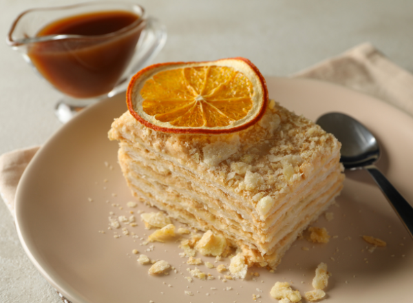 Наполеон – это слоеный торт с начинкой из заварного крема, который является одним из самых популярных десертов.-2