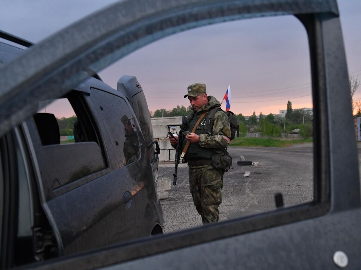    Боец МВД ЛНР проверяет документы у водителя на блокпосту в Волчанске Харьковской области© РИА Новости / Виктор Антонюк