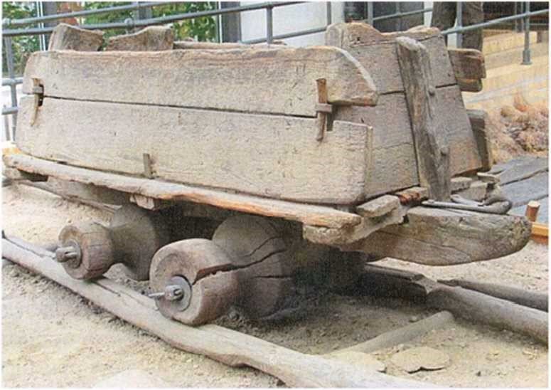 Картинка из свободных источников. Шахтный деревянный рельсовый путь и вагонетка, XVI в.