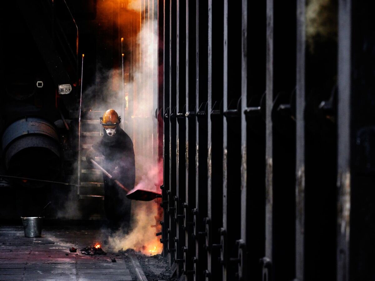    Рабочий у коксовой батареи на металлургическом заводе "Уральская сталь" в Новотроицке Оренбургской области© РИА Новости / Евгений Биятов