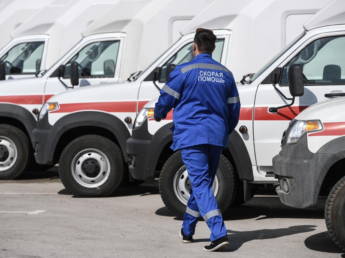    Сотрудник скорой помощи рядом с новыми автомобилями в Крыму © РИА Новости / Константин Михальчевский