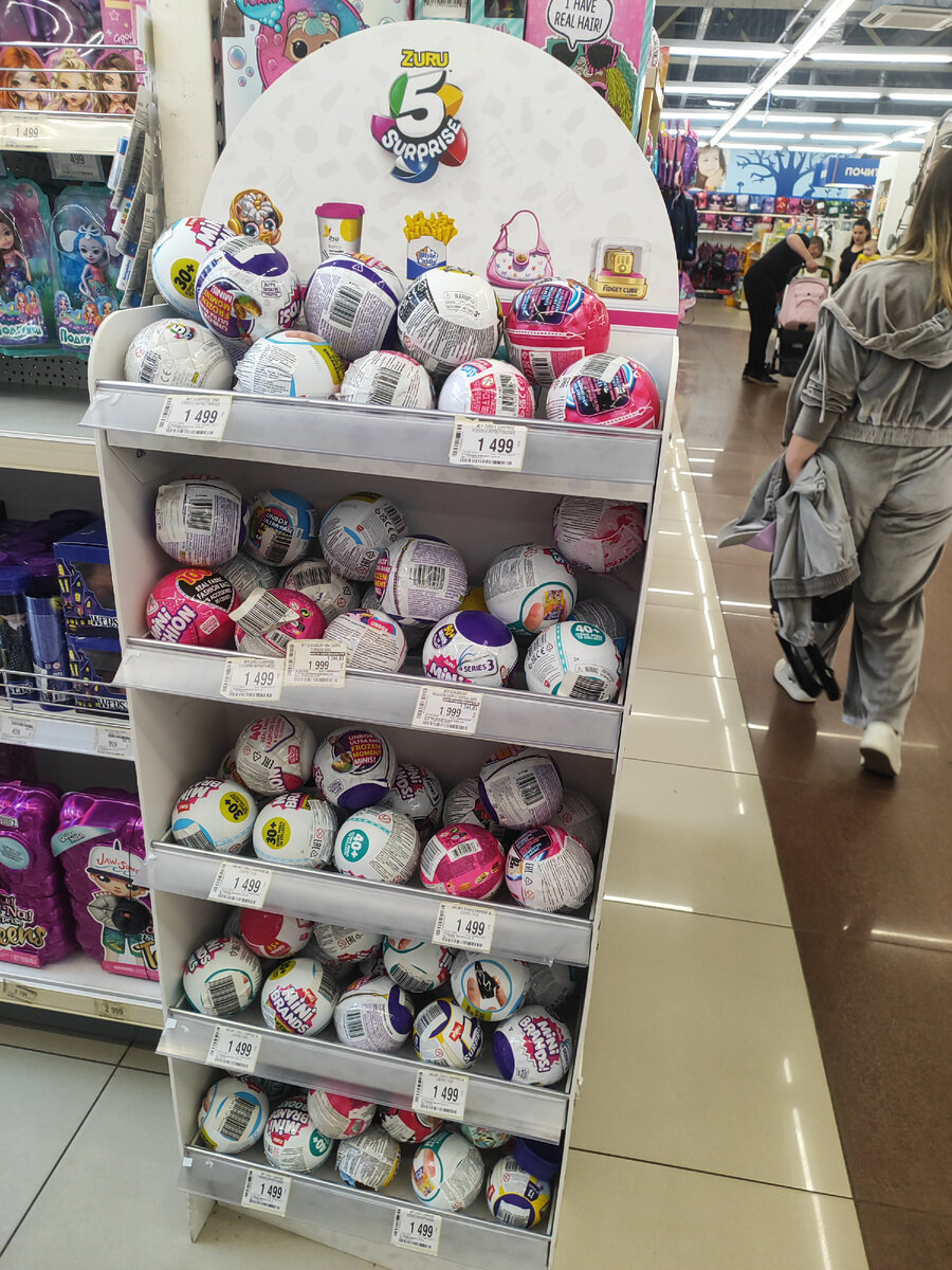 Ассортимент кукол, шаров, автомобилей и других игрушек в магазине "Детский мир" (ТК "Фиолент", г. Санкт-Петербург) . Фото автора.