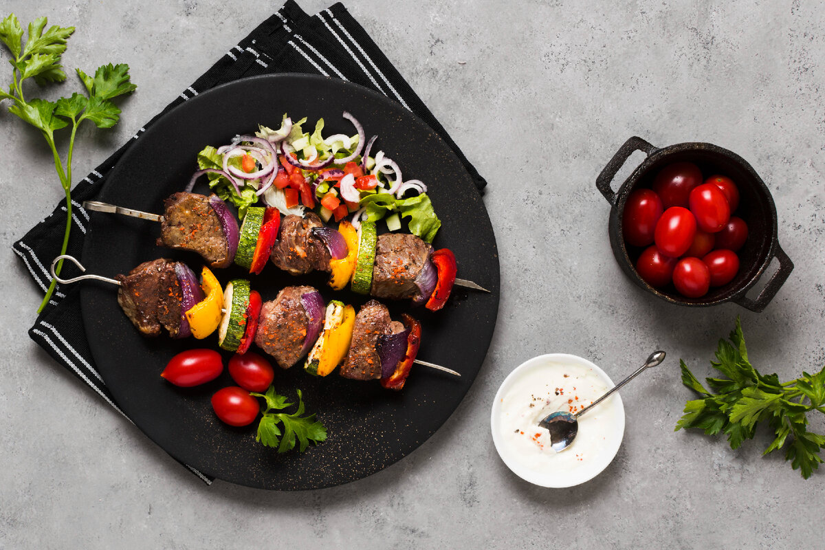 Шашлыки с овощами и соусом <a href="https://ru.freepik.com/free-photo/delicious-arabic-fast-food-skewers-black-plate-tomatoes_9877992.htm#fromView=search&page=1&position=14&uuid=2a03bec8-e3d4-436a-8014-8ab5925d0e4e">Изображение от freepik</a>