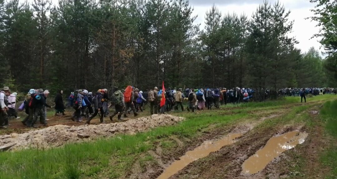 Тысячи людей идут в любую погоду, в том числе по бездорожью