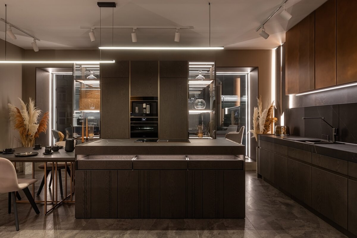 Кухня состоит из 3х частей: пристенной части с зоной хранения и крупной бытовой техникой, пристенной части с зоной мойки и большого острова с приставным обеденным столом.