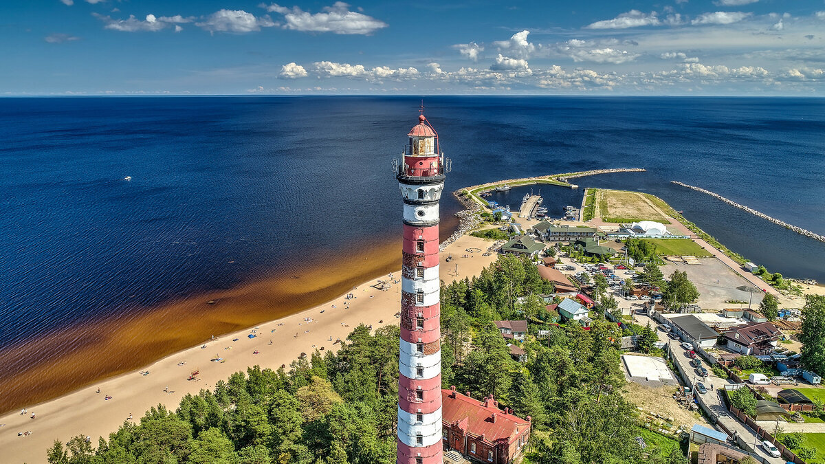 Главная достопримечательность пляжа — Осиновецкий маяк. Он построен в начале XX века и входит в список самых высоких в мире. Фото: Studio MDF / Shutterstock
