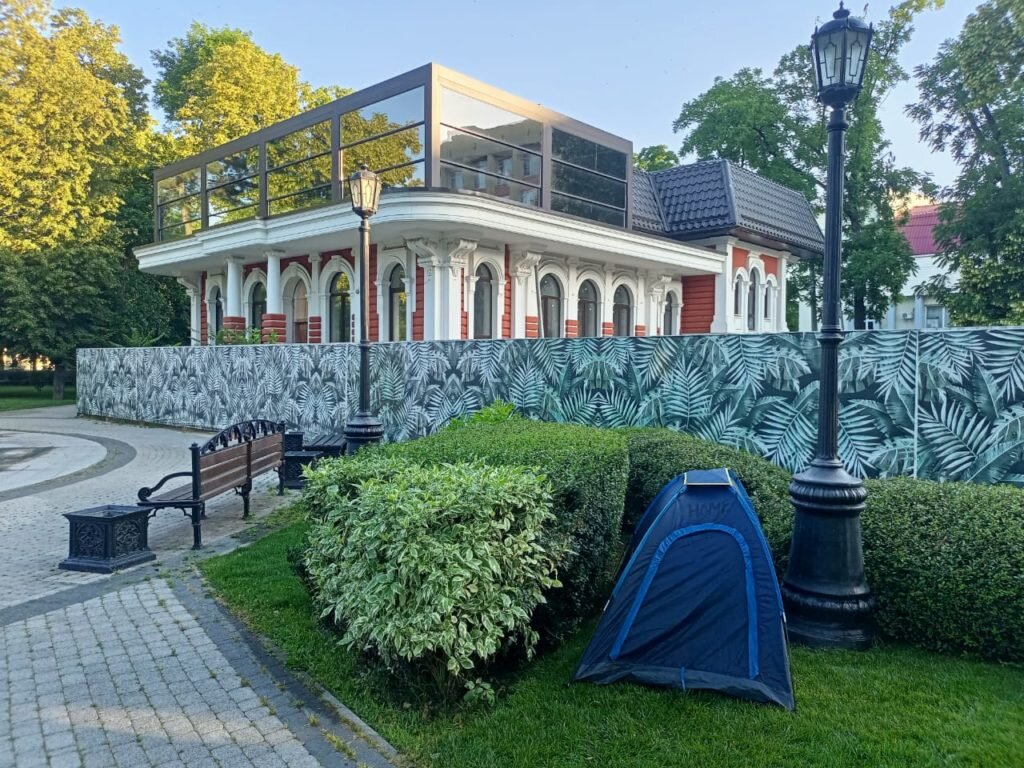 Палатка стоит в кустах 
