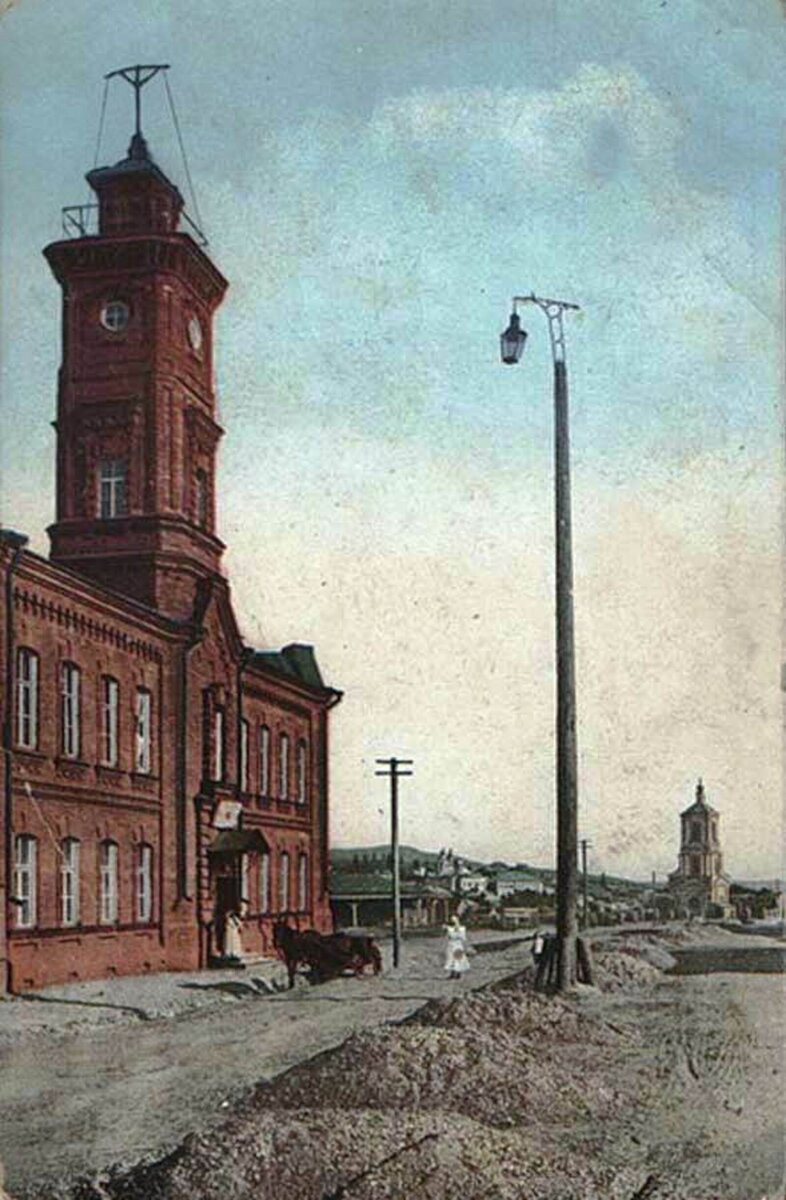 Пожарная каланча на ул. Большая Казанская (ныне ул. Октябрьской Революции). Впереди видна Троицкая церковь. Начало ХХ века.