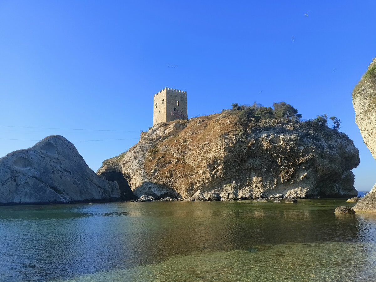 Вид на крепость с пляжа. Справа находятся пещеры