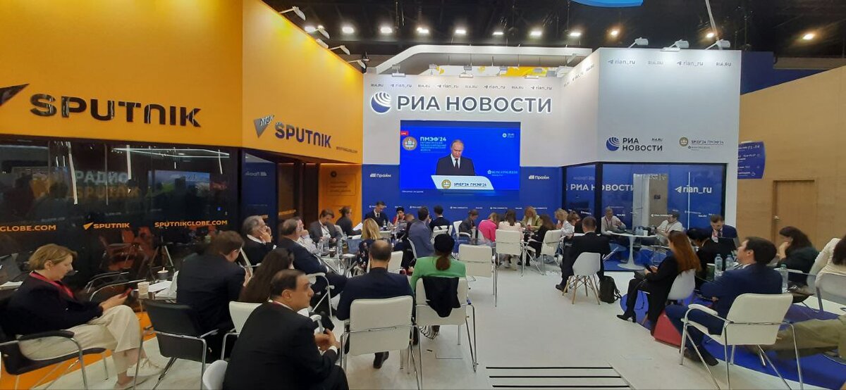 Журналисты и участники ПМЭФ-2024 слушают выступление президента России Владимира Путина