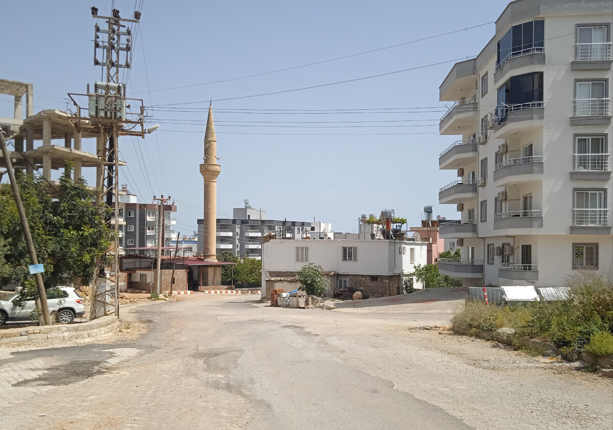 Улица Ташуджу. В одном кадре справа налеево: современная новая многоэтажка,, старый турецкий дом, мечеть, вышка сотовой связи и скетет сьроящегося дома. Обычный микс
