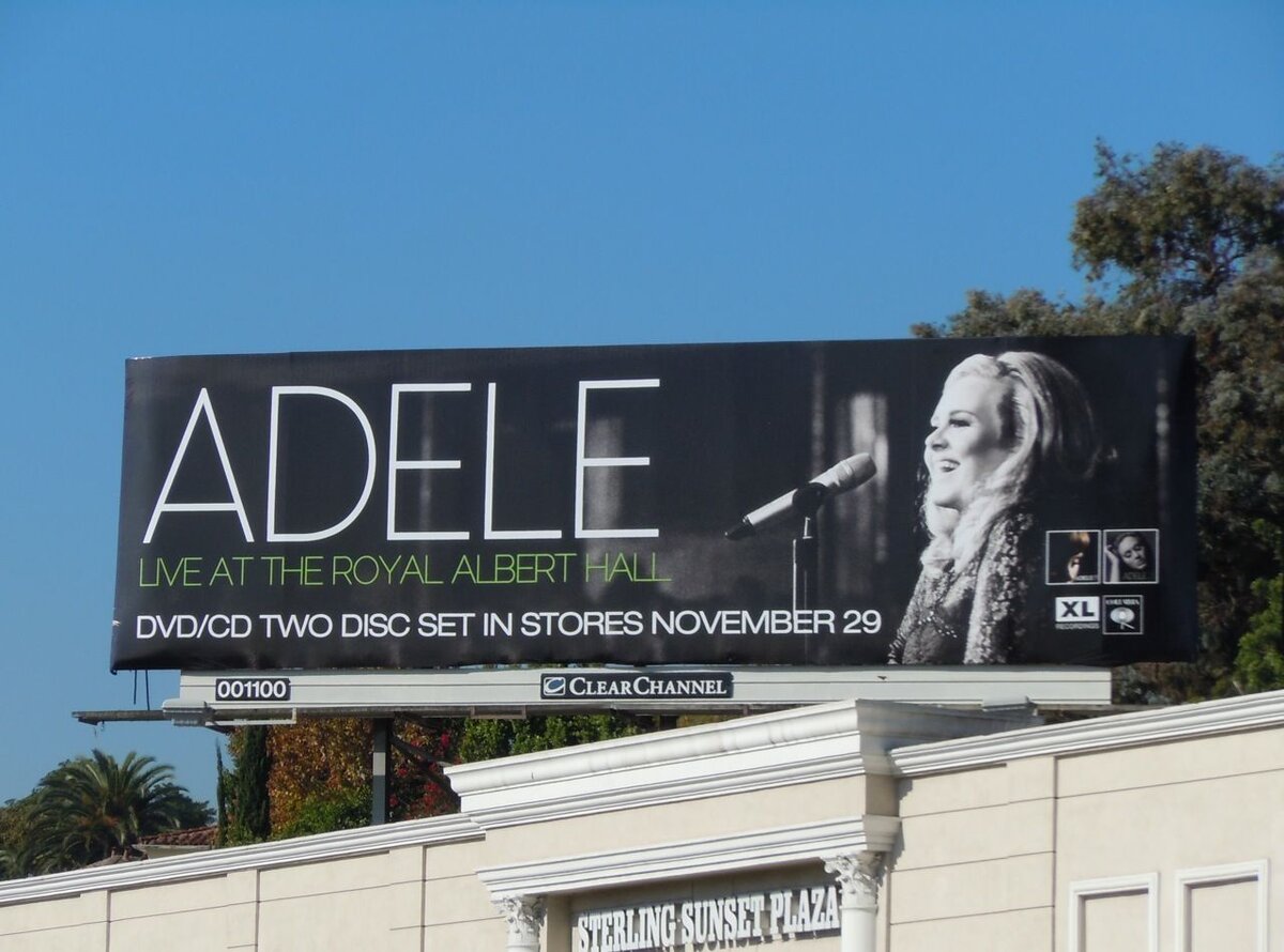 Эффективная наружная реклама музыкального концерта, информирующая о выпуске DVD/CD с концертом Адель в Альберт-холле, который будет доступен в магазинах с 29 ноября. 