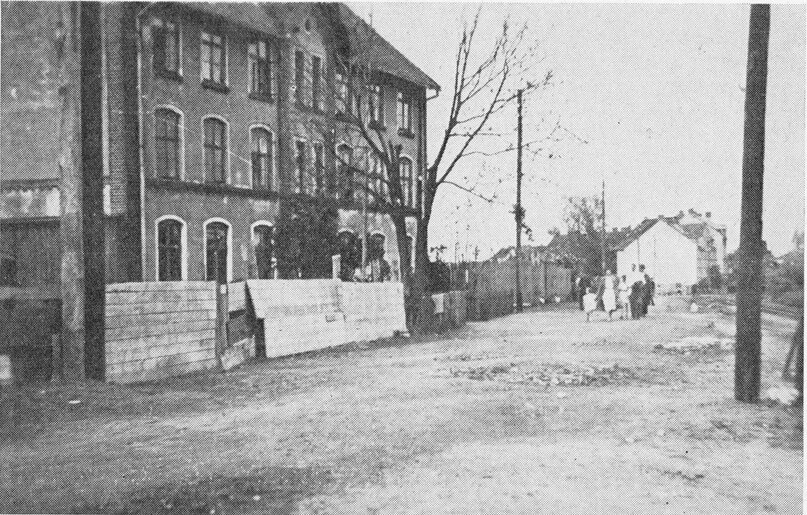 На фото перед домом по адресу Вальдхаузенерштрассе #18 можно видеть относительно неглубокую воронку от взрыва бомбы. Однако эффект от её осколков оказался поистине роковым.