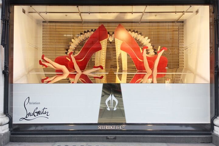 Эта витрина Кристиана Лабутена эффективно привлекает внимание своей яркой визуальной композицией, подчеркнутой гигантскими красными туфлями на высоком каблуке, которые являются узнаваемым символом бренда. 