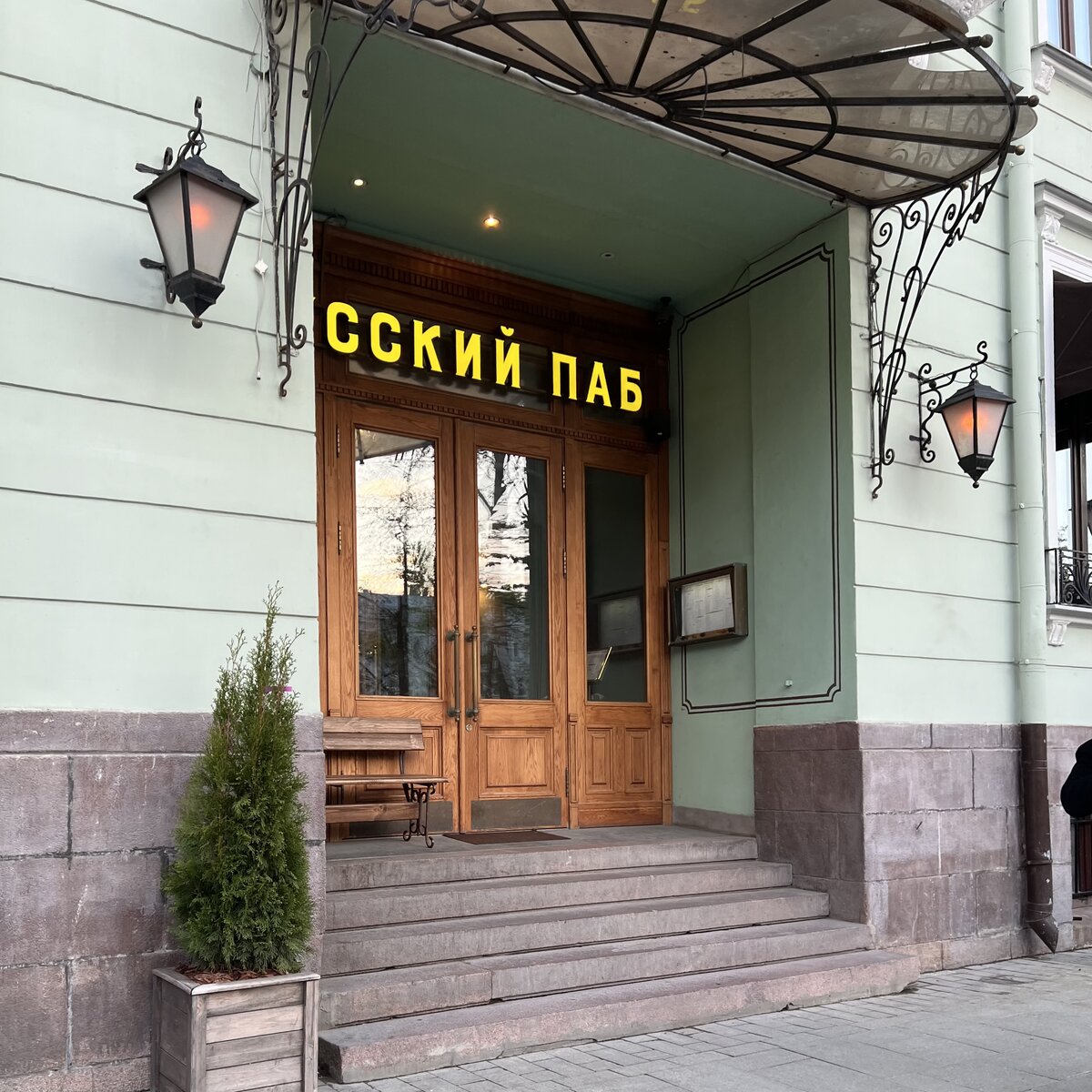 Вход в «Русский паб» находится на Тверском бульваре, недалеко от здания ТАСС. Желтая вывеска, большие старые деревянные двери в узорах, далее фойе и два обеденных зала.