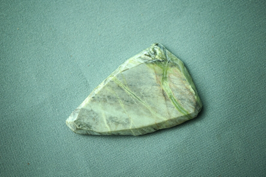 Заготовка кальцифира для кабошона, в реальности камень обладает слабым фиолетово-бардовым оттенком, на фото почти не видно.