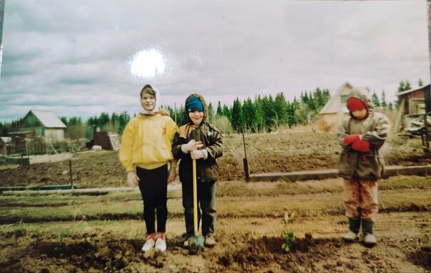 Сейчас огород скорее хобби, чем необходимость. Сел в машину, через час ты уже топишь баню,жаришь шашлык, а ноги щекочет травка. Конечно не у всех, но это дело каждого. Кому газон а кому грядки копать и ни кусочка земли не простаивает.
 Раньше выбора у нас не было,огород реально спасал, люди выживали на закрутках и картошке,раньше это в 90-е.
 Папе на работе каким -то чудом достался один из двух выделенных участков. Пол  участка занимали вековые ёлки ,позже на пеньке одной из них у нас был "штаб". Землей назвать то,что было под ногами сложно, там была глина похожая на камень.
 Лет с 6 нас стали брать на огород с собой. Это сейчас машина, а тогда даже автобуса не было, зато была электричка и потом пешком по бездорожью, поэтому и не брали. 
 Когда появился автобус, дорога не сказать что стала легче, но мы подросли и уже могли долго ходить. А ходить надо было действительно долго. Вообще у меня много вопросов  к конвенции по правам человека, куда они смотрели, как вспомню все эти приключения ,так вздрогну. Чтобы в автобус попасть и не ждать следующего, надо было встать в 6 утра,приехать с жд вокзала в центр( это около часа времени),хотя бы за 30-40 минут до отправления,  бабушки в первых рядах занимали очередь наверное с вечера. Зато они конечно сидели, мы не сидели никогда. Подъезжал старый ЛиАЗ, кто помнит, тот представил весь спектр эмоций связанных с поездками на нем. Все что может трясется, звенит,  болтается, стекло водителя обклеено монетами и наклейками из жвачек по рублю.
 Счастье, мы влезли, контакт  настолько тесный, что ты обнимаешь всех своих соседей сразу. Но это нормально, других вариантов нет ,все смирились и привыкли. Помимо людей в автобусе едет пара корзинок с котами, на задней площадке почти до потолка торчат саженцы. Пока едем по городу, все более -менее спокойно, даже на поворотах не сильно заносит. Но стоит съехать на гравийку, до сих пор помню те кочки. Весь автобус,люди , сумки, ведра подпригивали на пол метра вверх. Смешалось все, корзинка открылась и чей-то кот удрал между авосек.
 Приехали, конечная, до нашего массива автобус не едет, поэтому пешком два километра. В принципе после одной такой поездки можно было проклянуть всё. Но мне было 6 и проклятий никаких я не знала. И вообще все происходящее вокруг мне даже где-то нравилось, было интересно. Домой все равно раньше вечера не попасть, поспать тоже не удастся, оставалось радоваться тому что есть.
 На нашем участке был небольшой сарай с лежанкой, печка была на улице. Папа работал сварщиком и варил ее сам и тащил кстати тоже сам на себе, она огромная и очень тяжёлая. Я даже маленькая понимала что дотащить ее огромные силы нужны, а сейчас просто аплодирую родителям стоя.
 На  печку ставили чайник , в кастрюле варили суп с тушёнкой и лапшой "Александра и Софья". Вкуснее того супа я наверное ничего в жизни не ела и не получается он такой , возможно дело было в той волшебной печке,а возможно в свежем воздухе и утренеем марш-броске.
 Родители работали, мы не мешались ну или почти не мешались. В 6 лет уже помогали закидывать картошку, во время посадки и потом доставать когда выкапывали. 
 -" Папа там жук тигр! Полосатый!"
Увидела я необычно красивого жучка, как потом оказалось жук был колорадским и его обязательно надо было давить. Личинки собирали в стеклянные банки, выносили на дорогу и давили пока они не успели уползти. На протяжении всей улицы были кучи братских жучьих кладбищ.
 Малину помню собирала, а она же высокая, я собирала снизу. Папа потом спрашивал, почему не собрала сверху, там самая вкусная, а я ее просто не видела . Высокую вишню собирали забравшись на бочку, в жару в этой же бочке папа нас окунал. 
 Было и такое ,что мама приехала специально собрать ягоды, навстречу шел мужчина, поздоровался ,как потом оказалось он шел с нашими ягодами, а мама уехала уже с пустыми руками . Тогда воровали только в путь, тащили как говорится все что не приколочено. Дедушка в очереди на остановке рассказывал, пришел к себе на участок,а там его картошку копают. Чтобы не побили, прикинулся таким же воришкой, помог, картошку поделили, хоть часть досталась и тому был рад.
 Было хорошо, если автобус ехал от нашего массива, нас тогда отправляли пораньше занимать очередь, пораньше это часа за полтора, зато обратно мы точно ехали сидя.
 Но автобус мог не доехать,тогда уже груженые урожаем шли пешком до следующего массива. Домой добирались быстрее, доезжали до окраины и спускались пешком минут 15.
 Обязательно мыться, потом все остальное. Мы были смертельно уставшие, пахли пылью и соседями с которыми обнимались в автобусе, в носках было по пол кило песка на каждый  а под ногтями земли на маленький цветочный горшок .
 Не знаю, что из этого было счастьем, суп, малина или дорога по полю, но могу сказать, что оно точно было,самое настоящее.