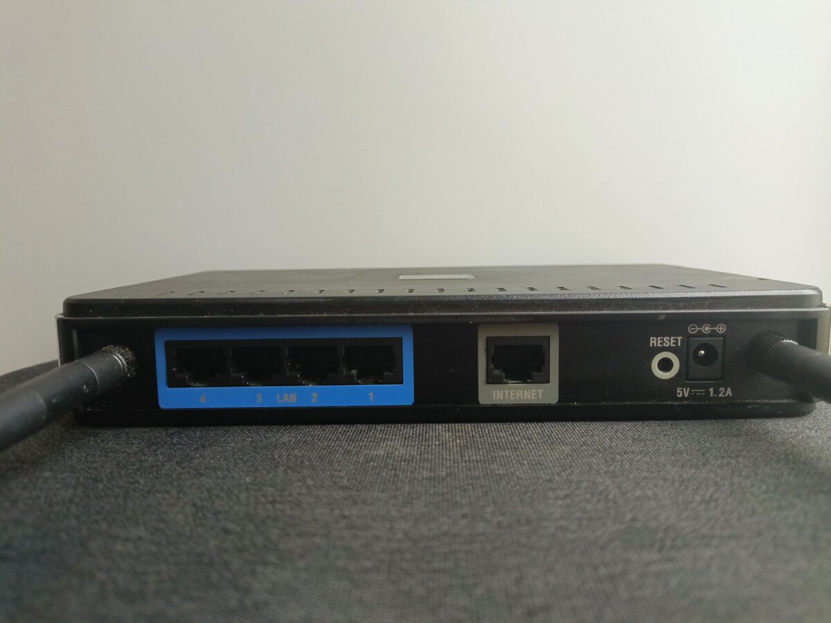 Пример расположения разъемов на роутере: 4 LAN-порта, Internet, спрятанная в углубление кнопка сброса, разъем для блока питания