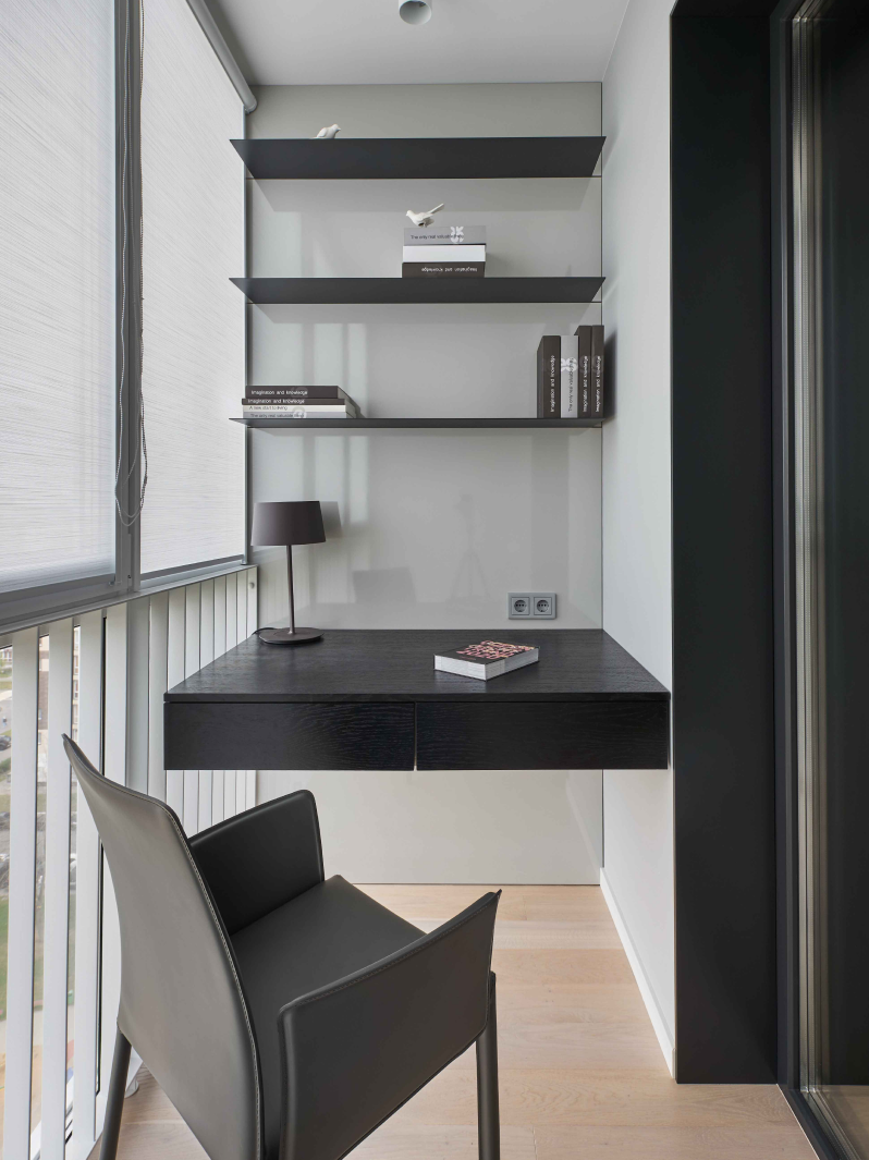Три подвесные полки, мягкое кресло и парящая столешница — минимум предметов создают комфортный кабинет.