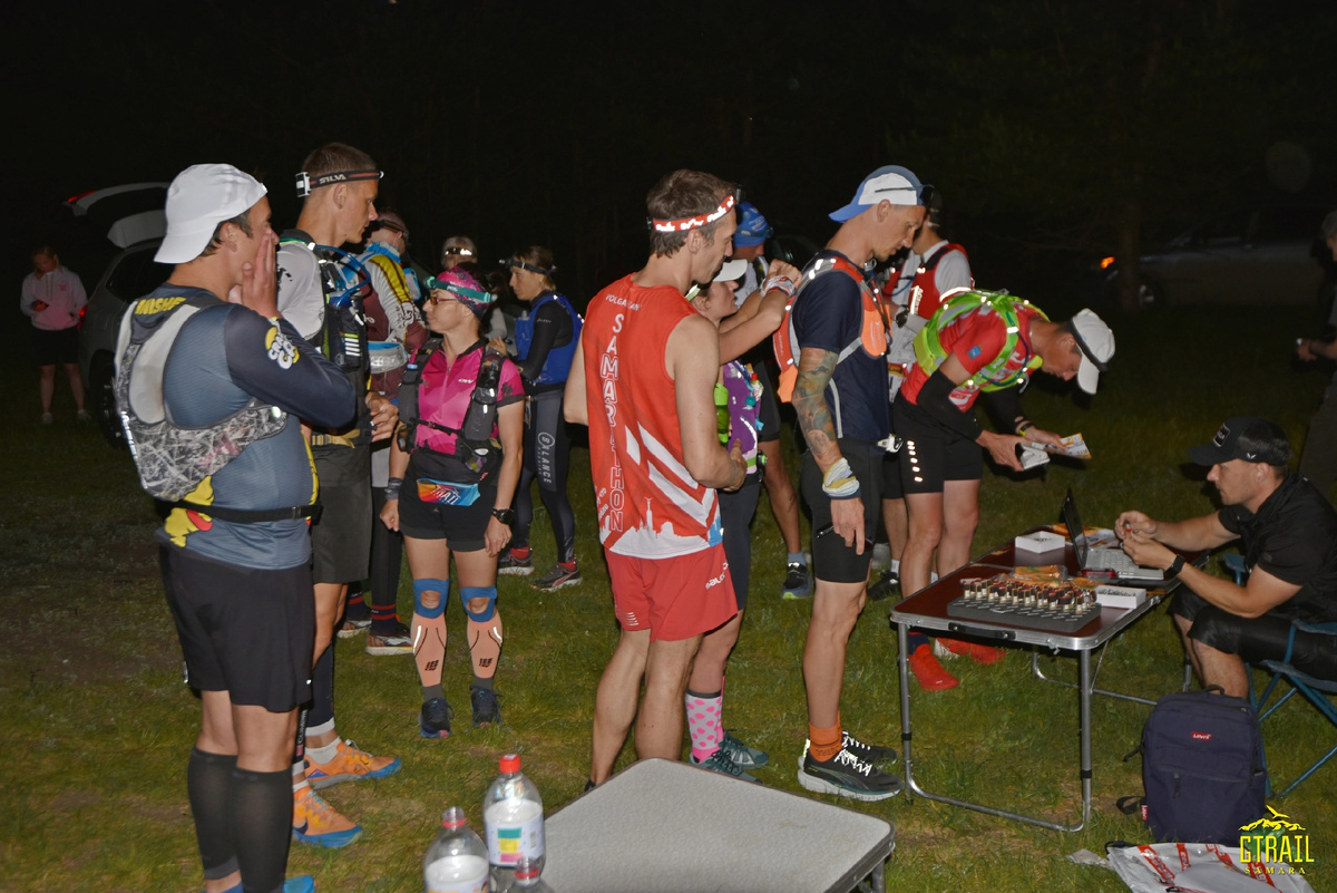 Участники ночной гонки на 50 и 100 км выстроились в очередь за получением стартовых номеров и чипов.